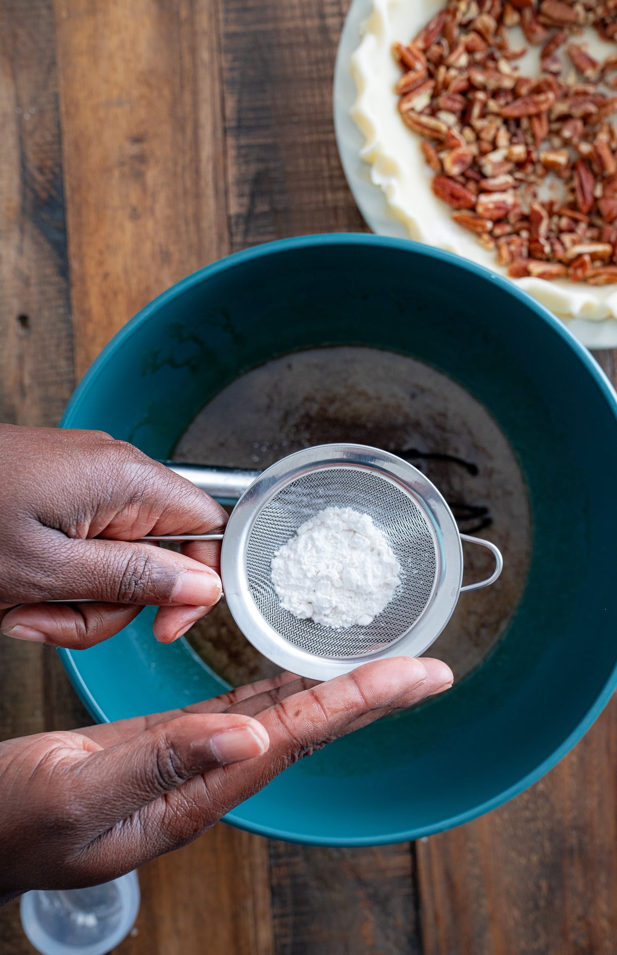 flour sifting into pecan pie