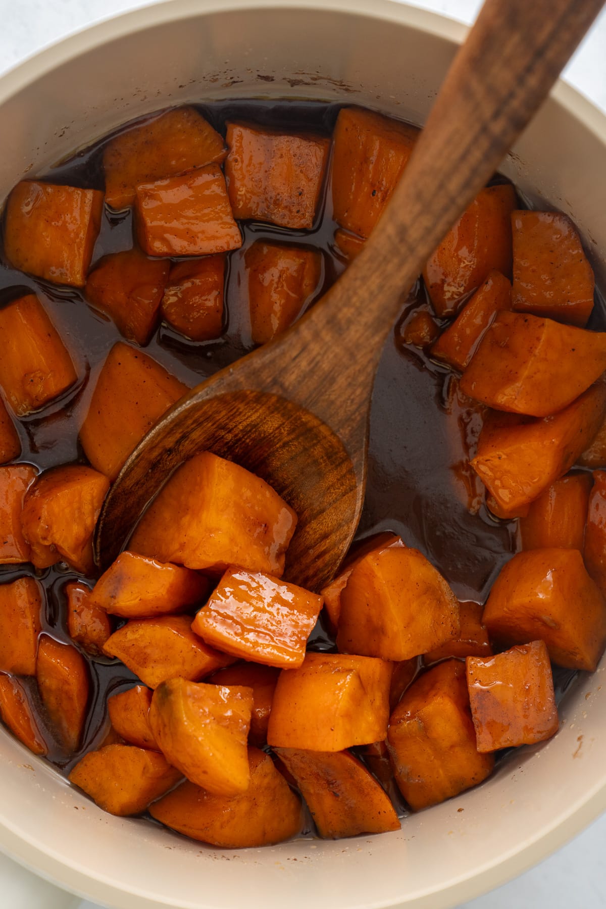 candied sweet potatoes with spoon sticking inside of pot