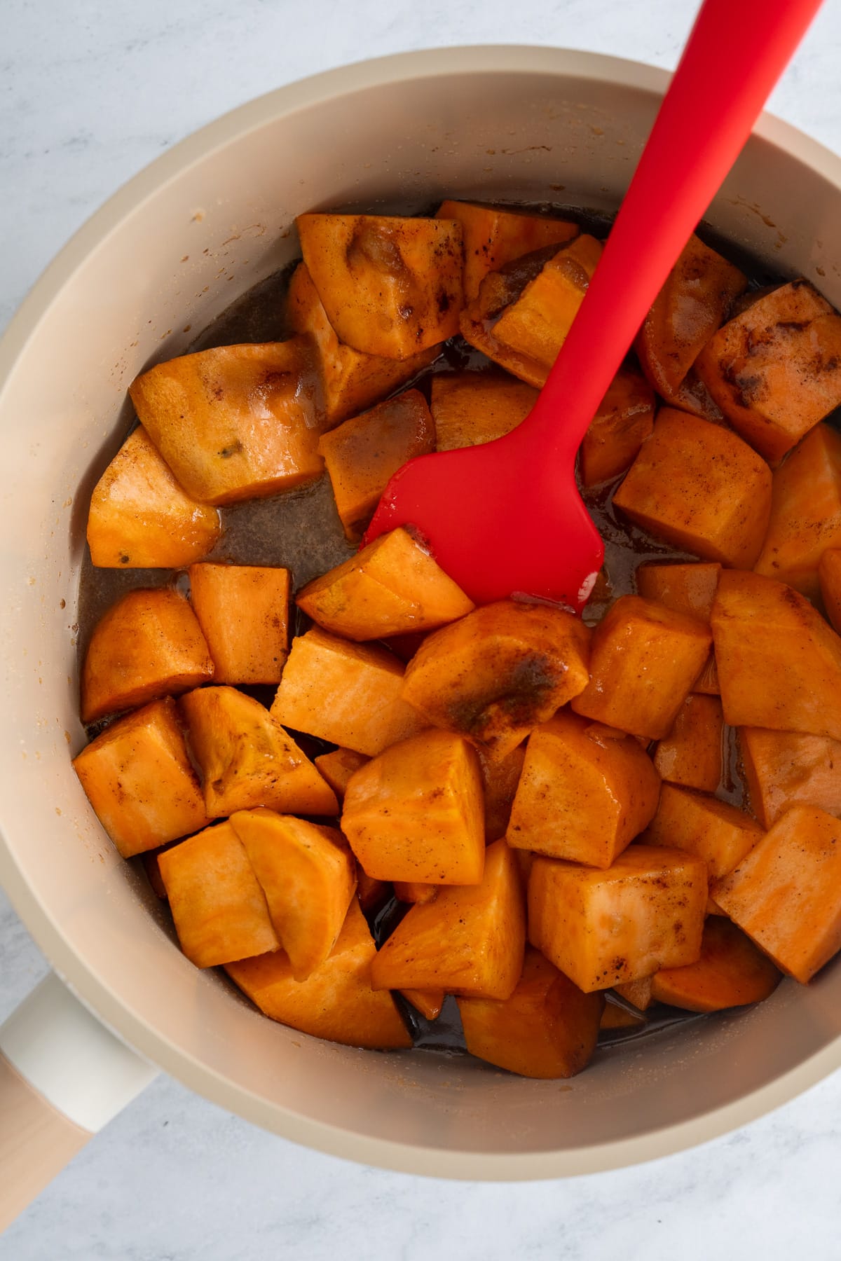 candied sweet potatoes halfway during cooking being stirred