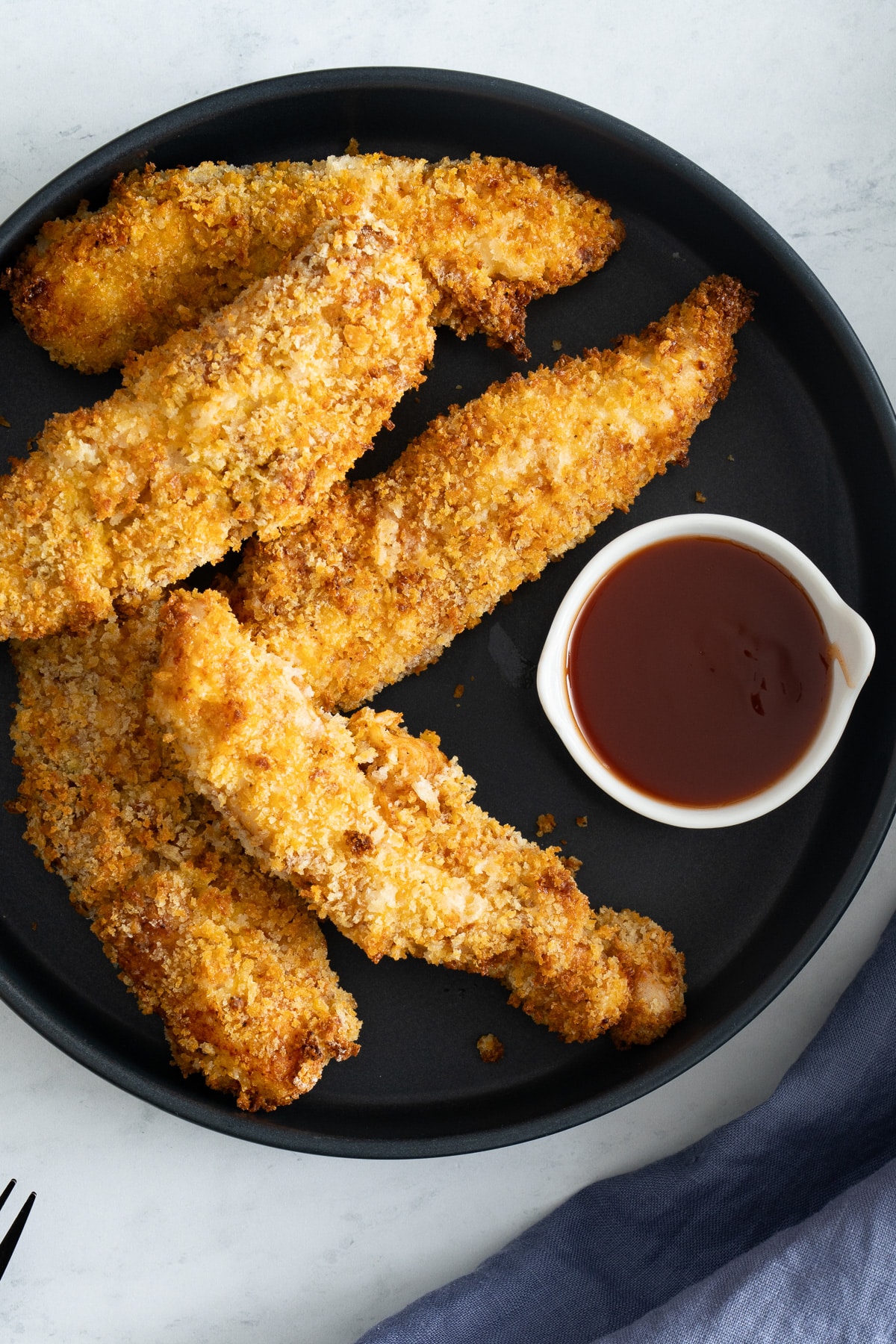 chicken tenders on plate with sauce on side