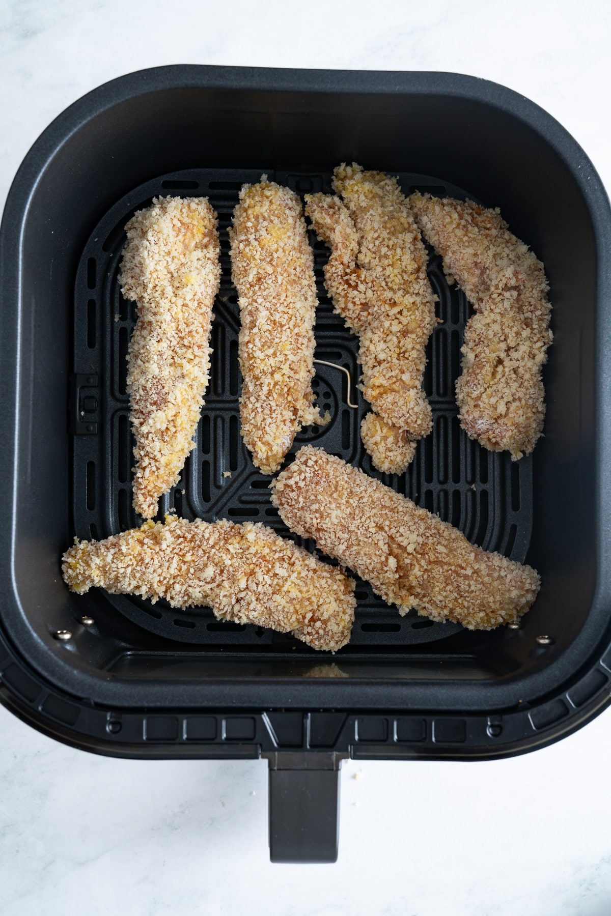 uncooked chicken tenders in basket