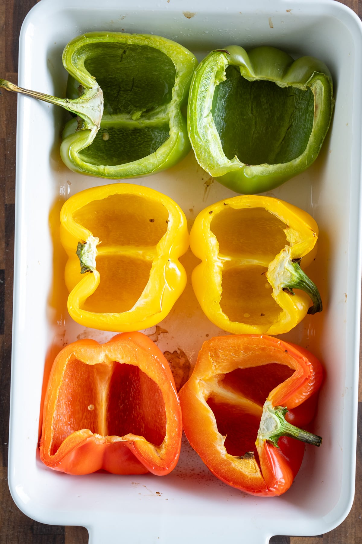 baked bell peppers cut in half in baking dish