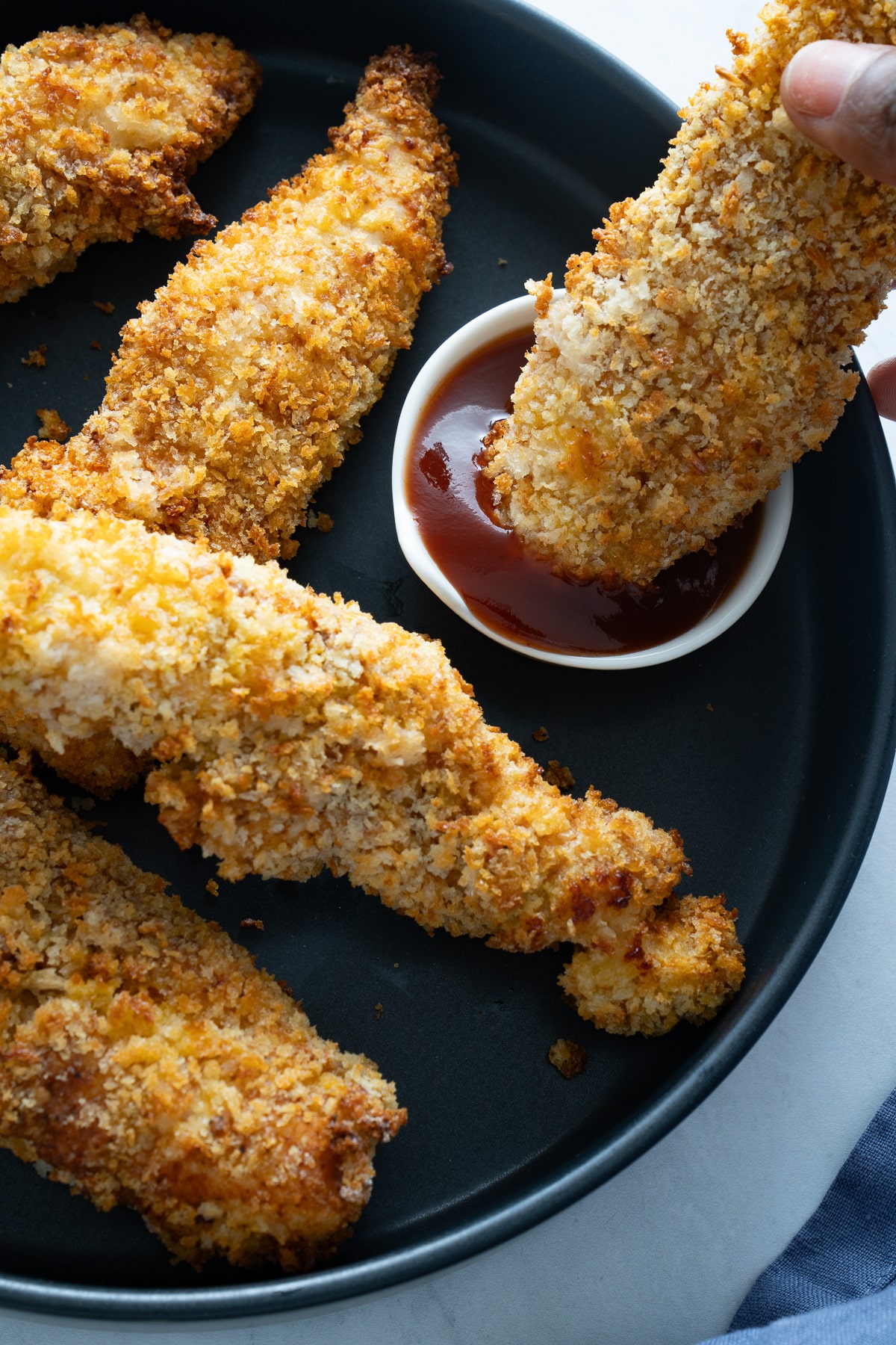 chicken tender being dipped into sauce