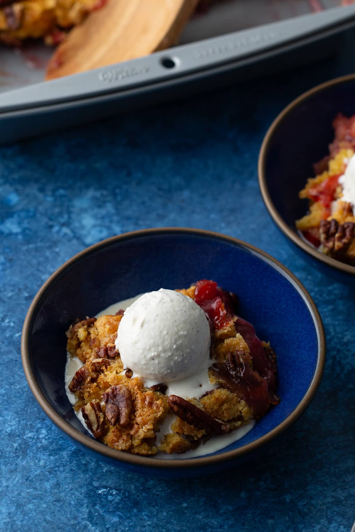 cherry pineapple dump cake in bowl with ice cream on top