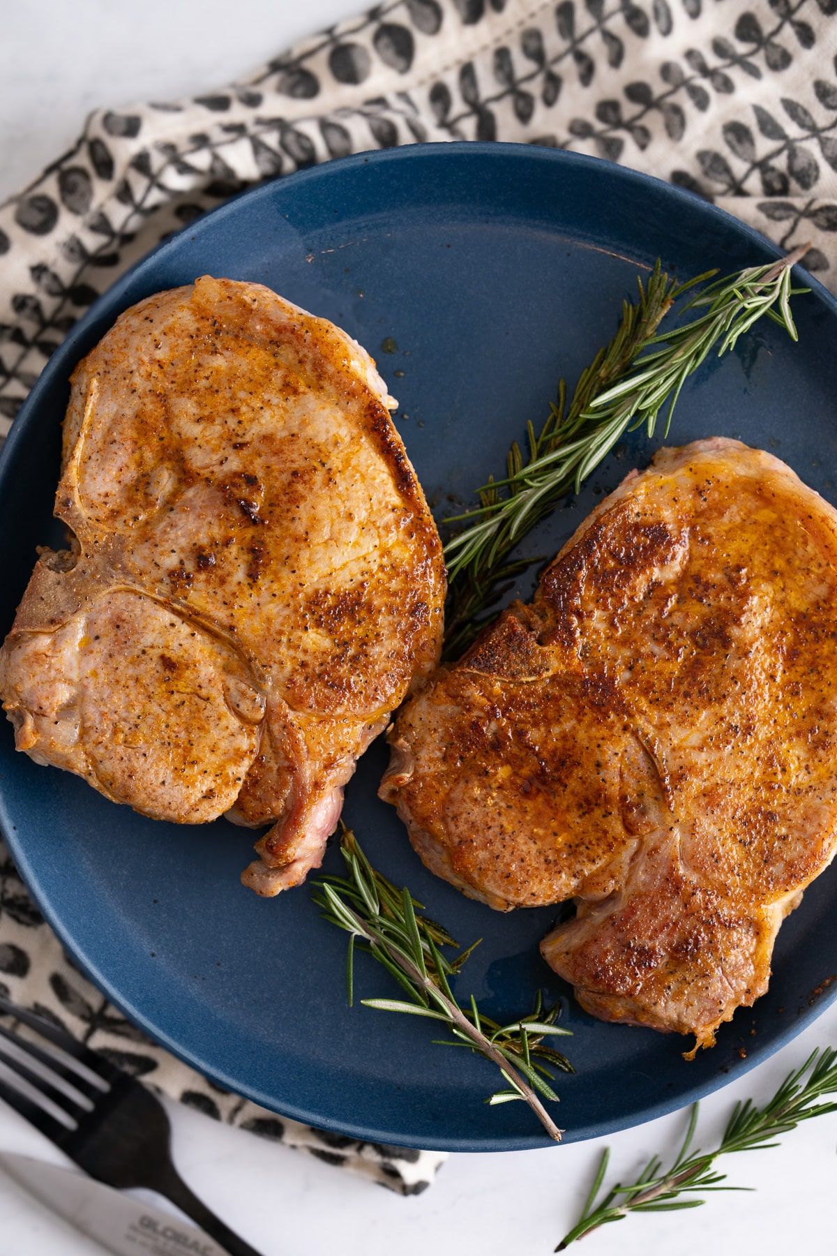 pan seared pork chops on blue plate