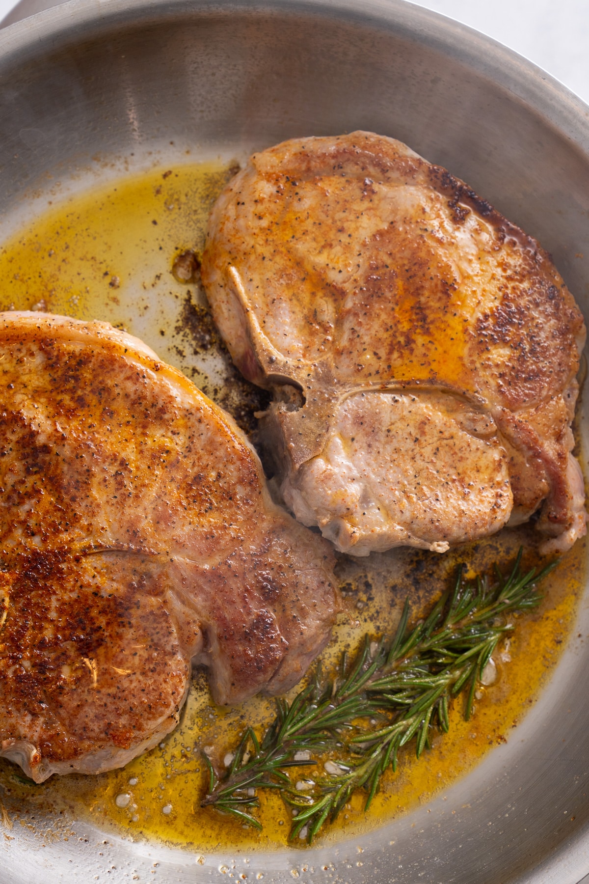 pork chops in the pan with rosemary