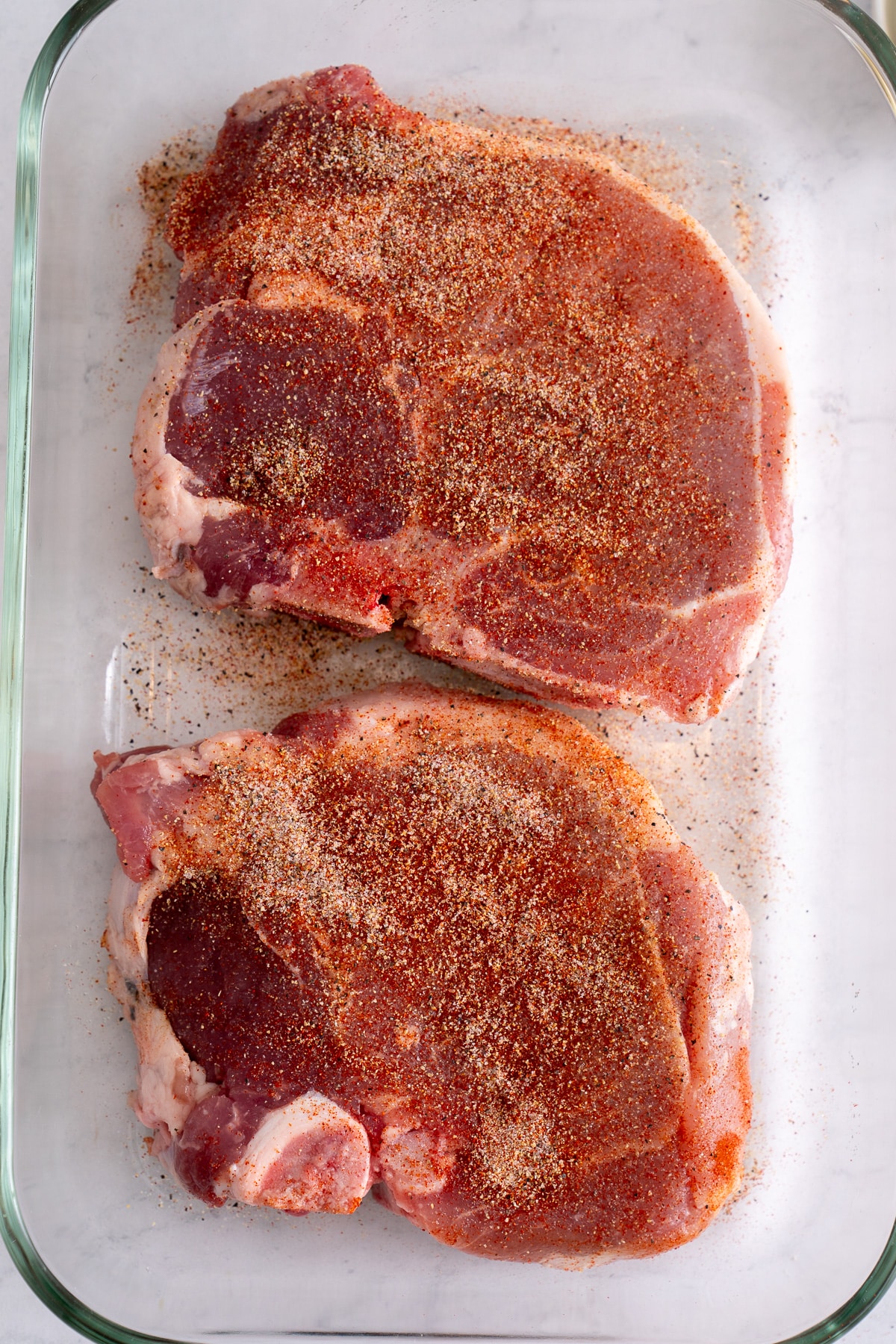 seasoned raw pork chops in the glass