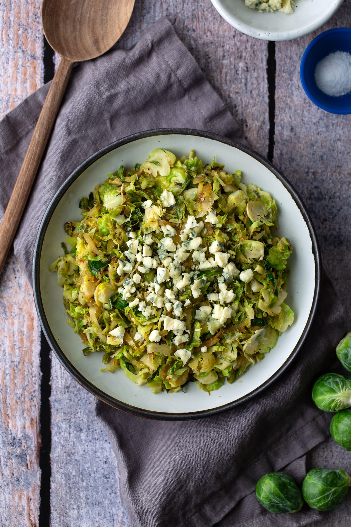 sauteed shredded brussels sprouts with spoon in side and in white bowl