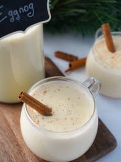 eggnog in glass with cinnamon stick sticking out