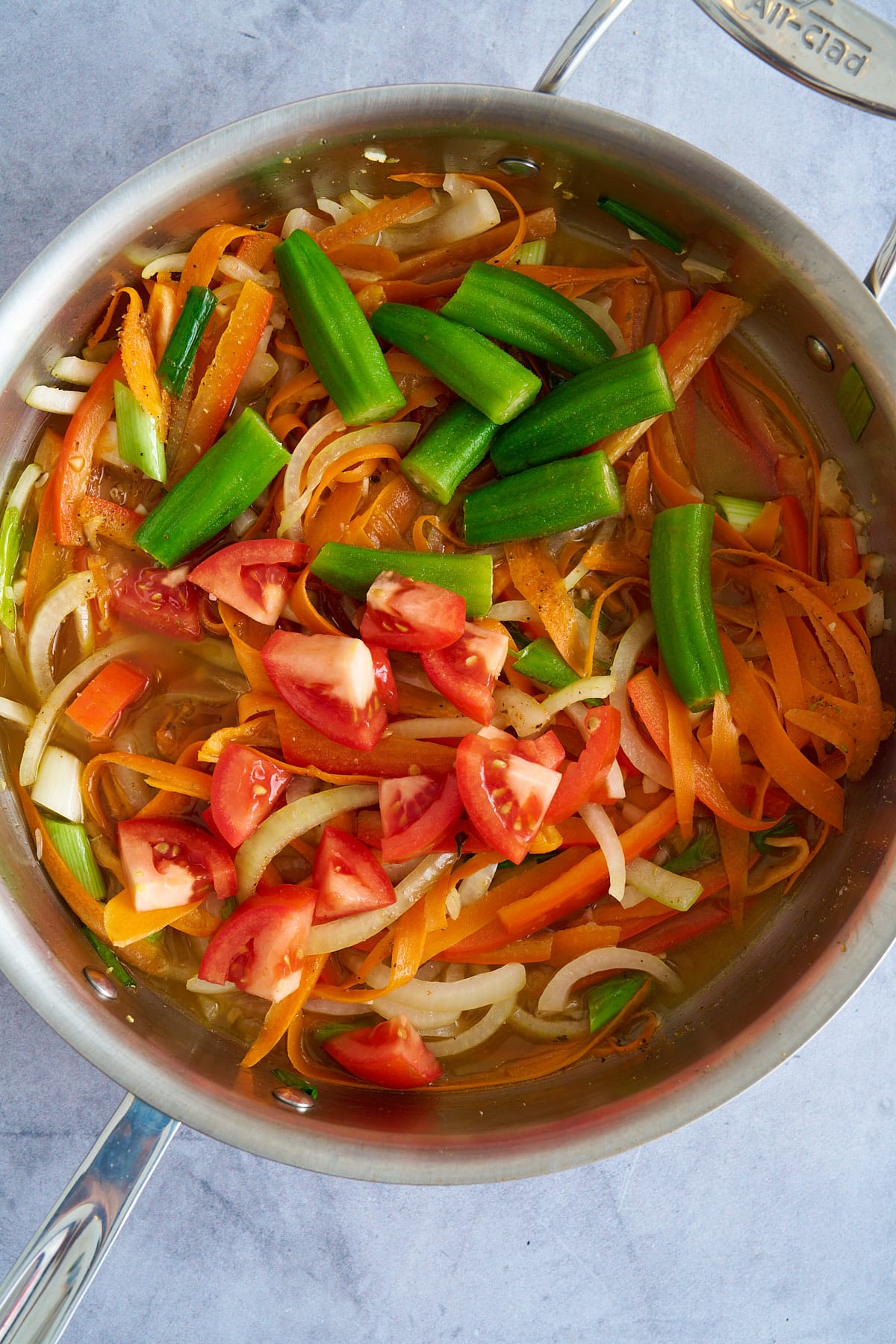 vegetables in saute pan with vegetable broth on bottom