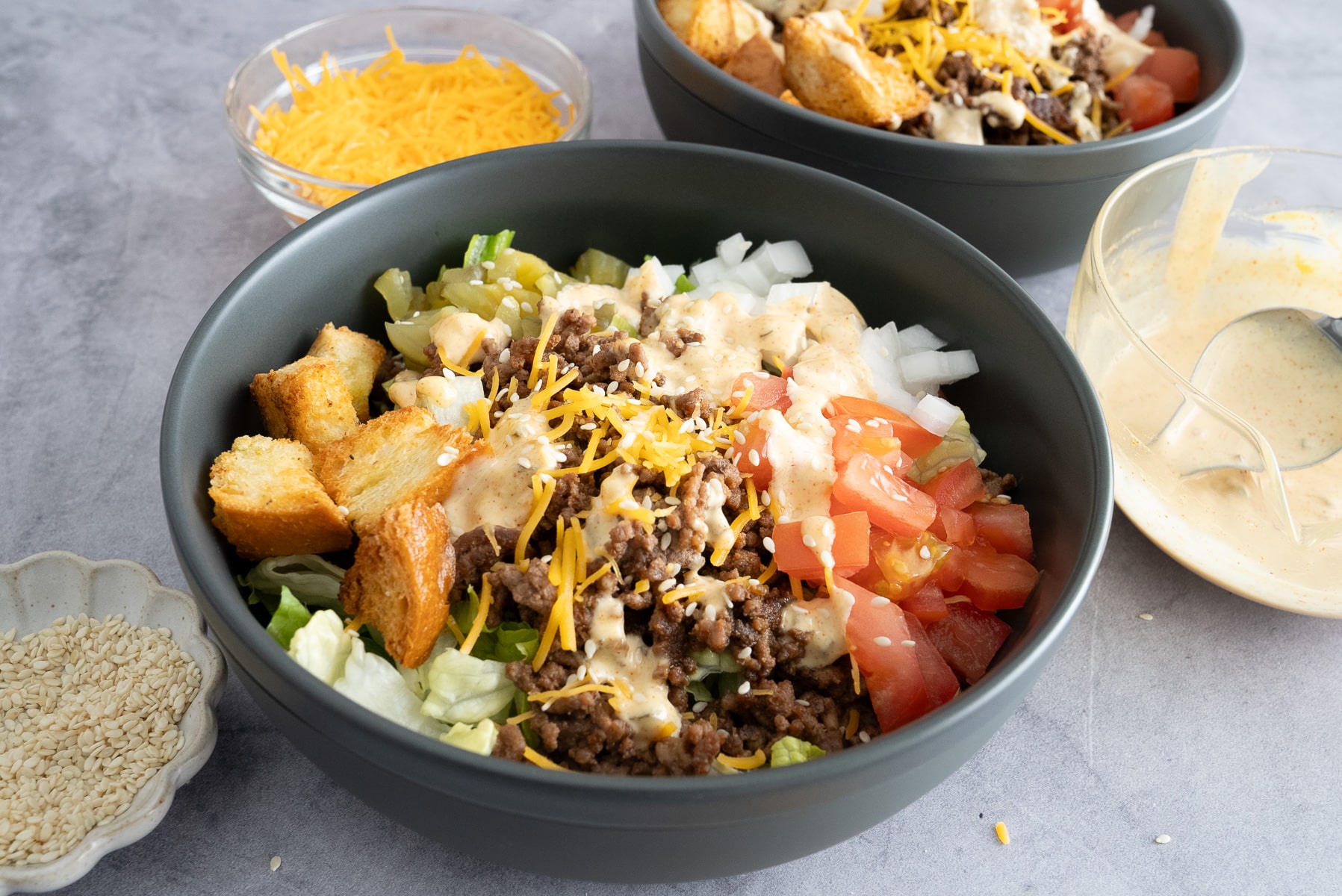 big mac bowl on table with toppings surrounding bowls