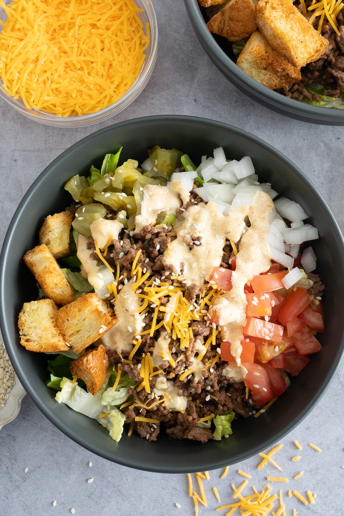 big mac bowl on table with toppings surrounding it