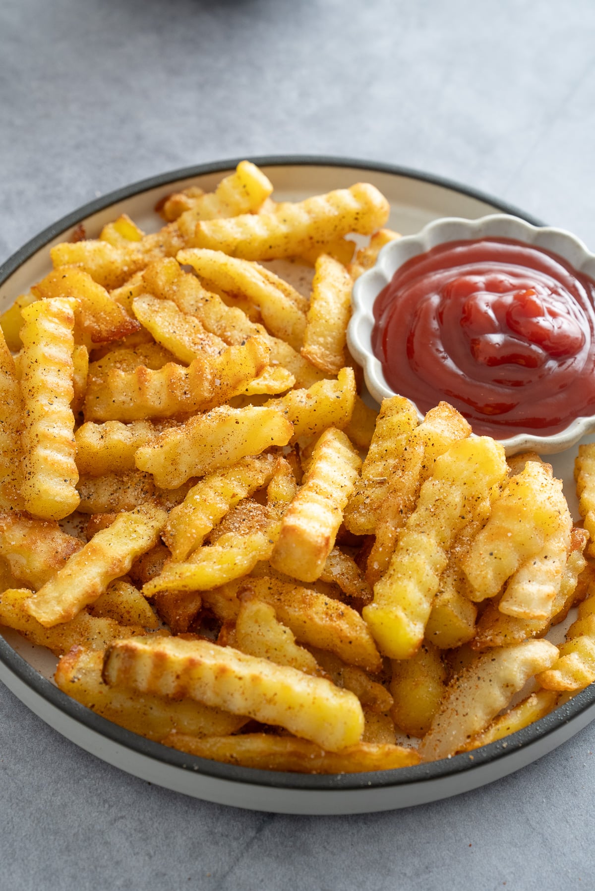 seasoned french fries on plate with ketchup