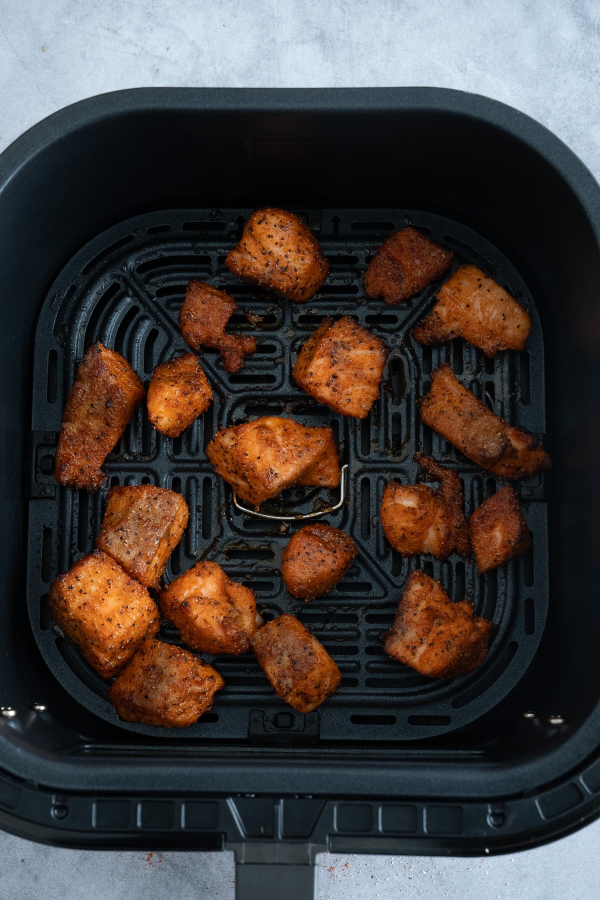 salmon cooked in an air fryer basket
