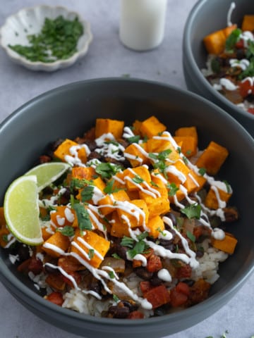 Sweet potato and black beans on rice with toppings on table