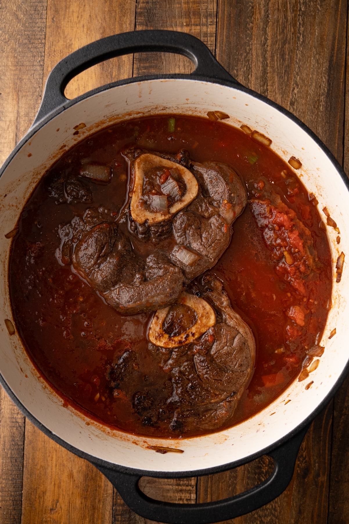 beef shanks in pot covered with braising liquid