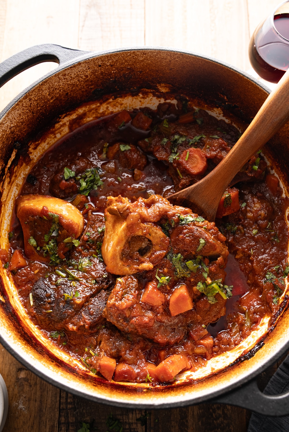 braised beef shanks in pot with spoon picking up beef shank