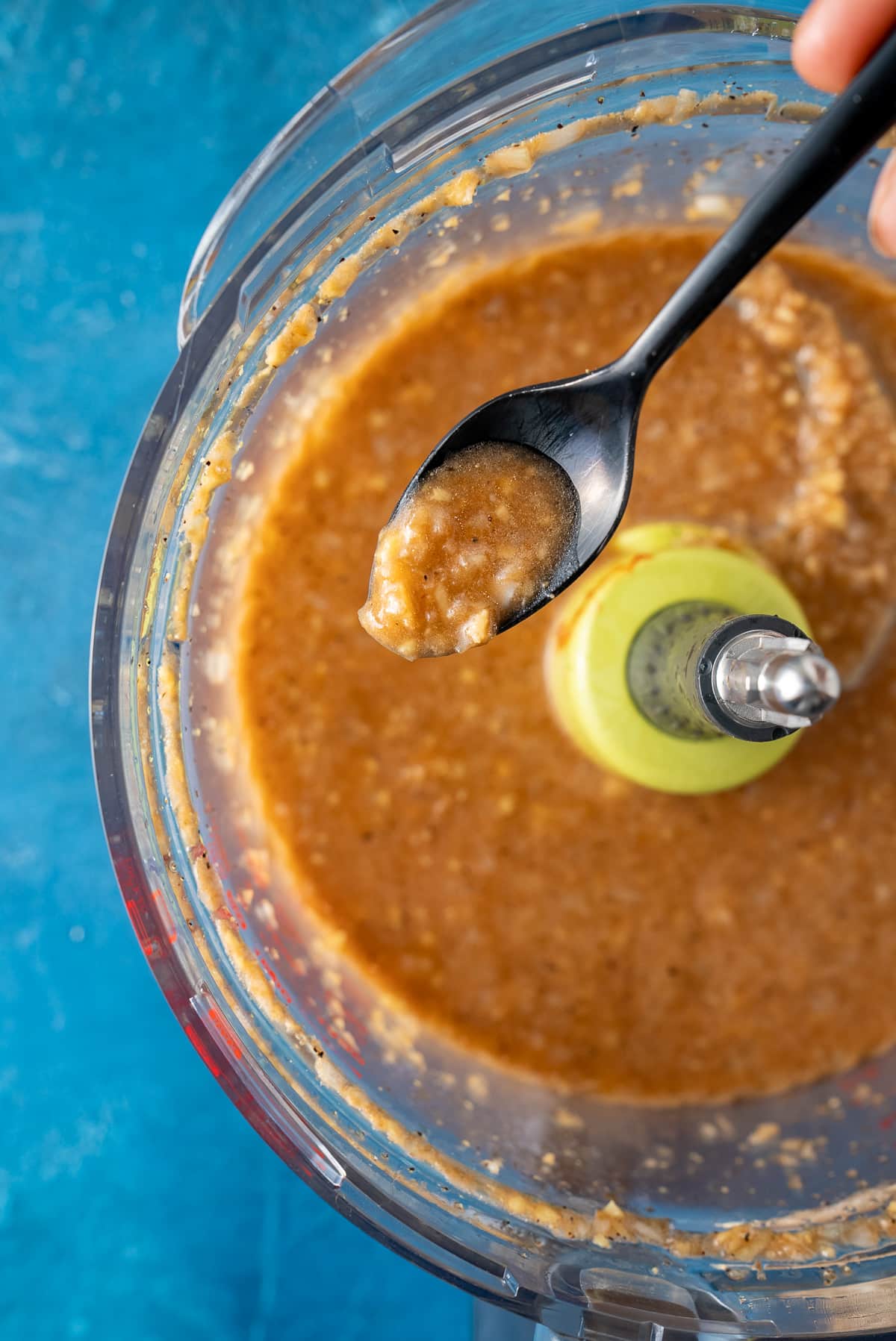 spoon holding up ginger dressing to show texture