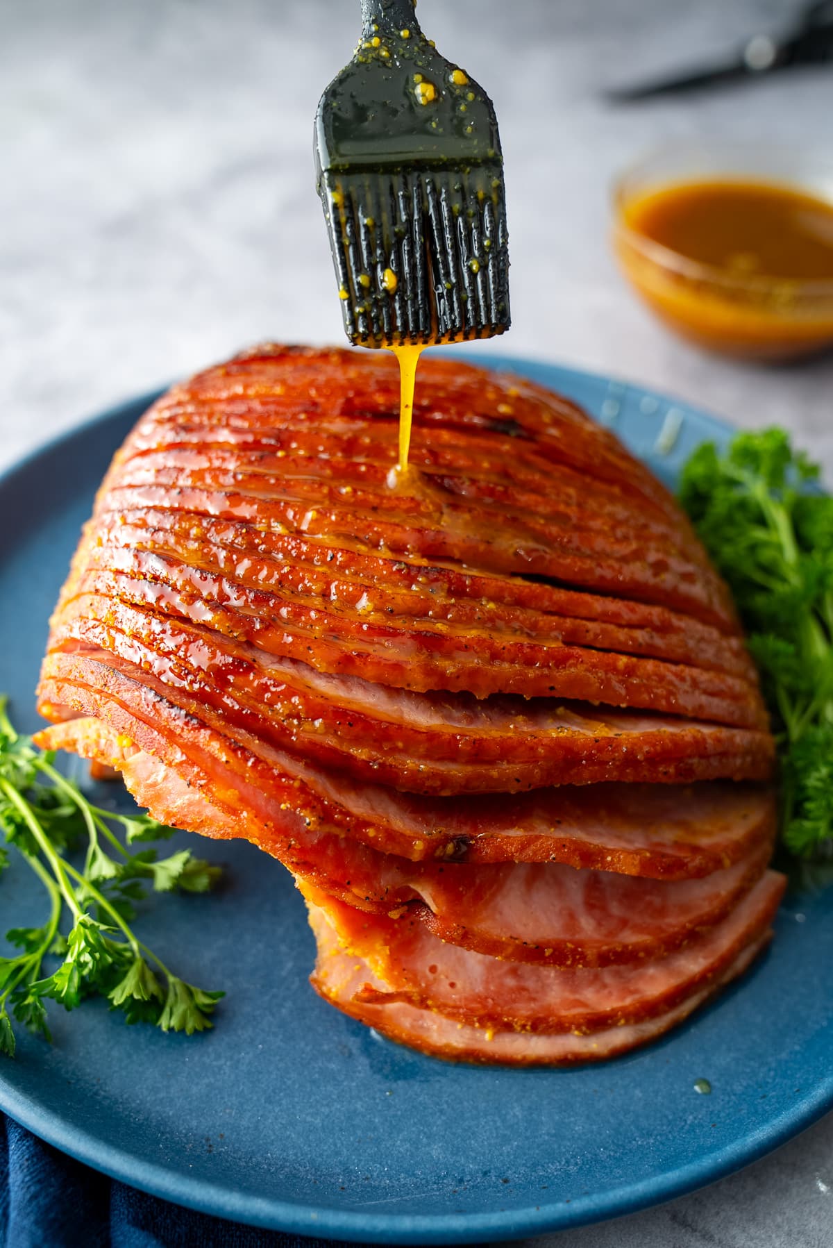 ham glaze dripping on ham from pastry brush