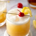 whiskey sour in glass with cherry on top