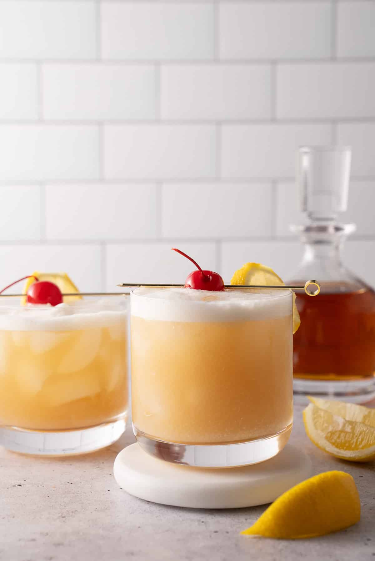 whiskey sours in glass with cherry on top